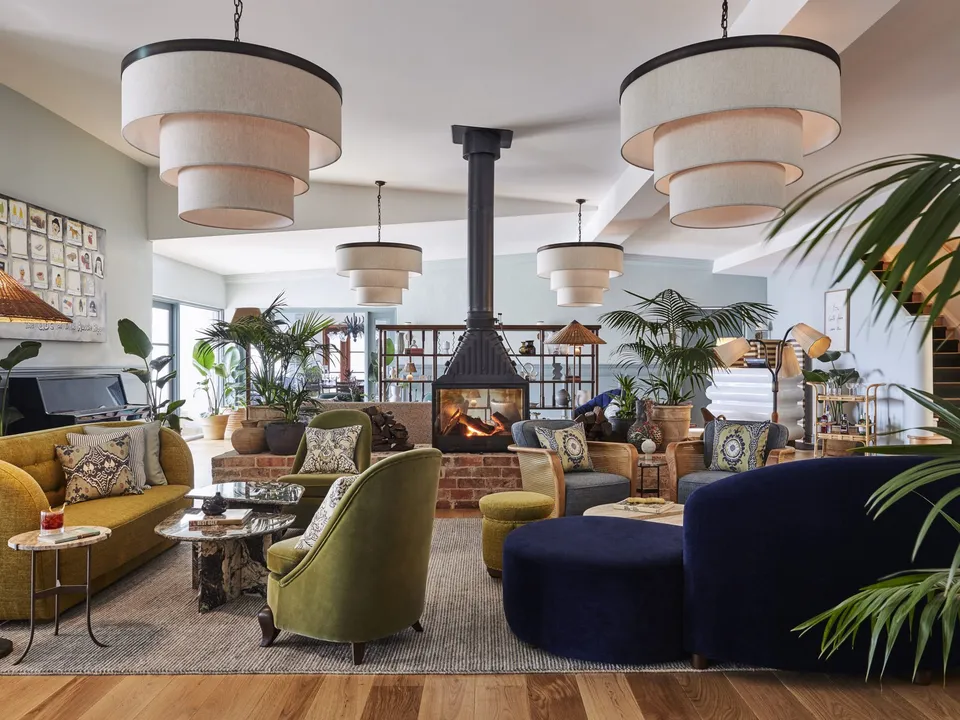 The main lounge at Osborn House with its signature tiered pendant lights and crackling fireplace