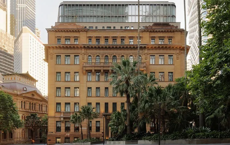 Capella Sydney: a sandstone hotel exterior framed by palm trees