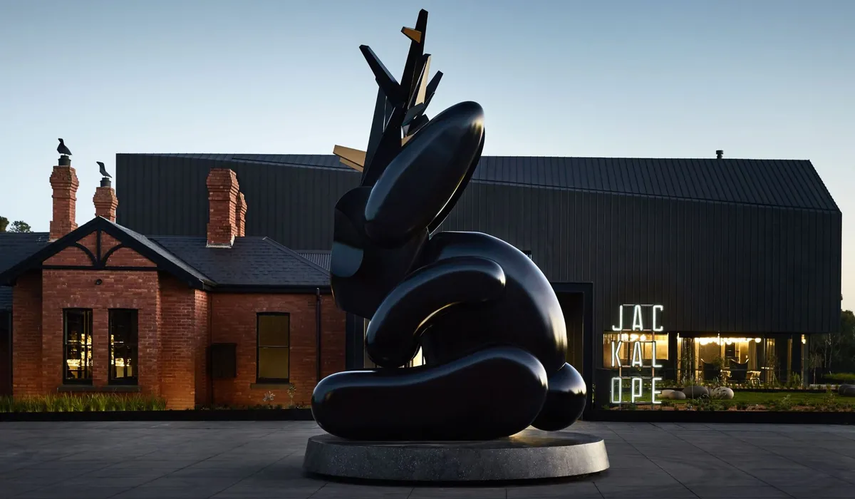 Jackalope Hotel, Merricks North: a sculpture before brick and dark timber buildings