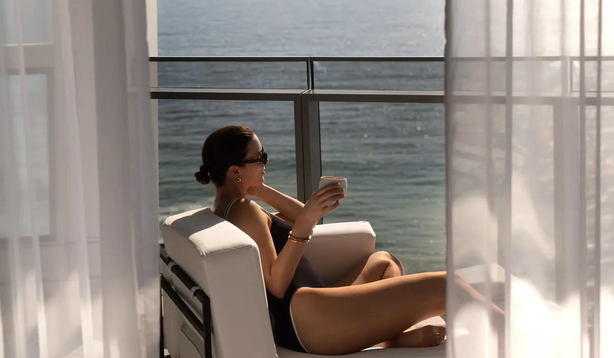 The Langham, Gold Coast: a woman seated on a balcony overlooking the sea