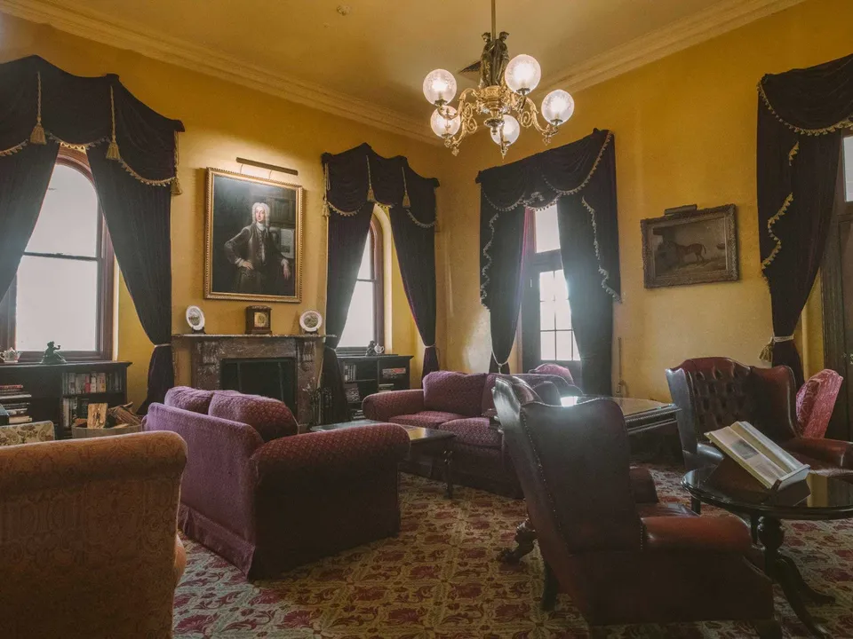 The Library with open fireplace and rich timber panelling