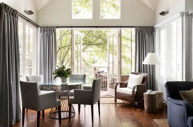 The Sutton Suite living area with vaulted ceilings and views through the garden canopy